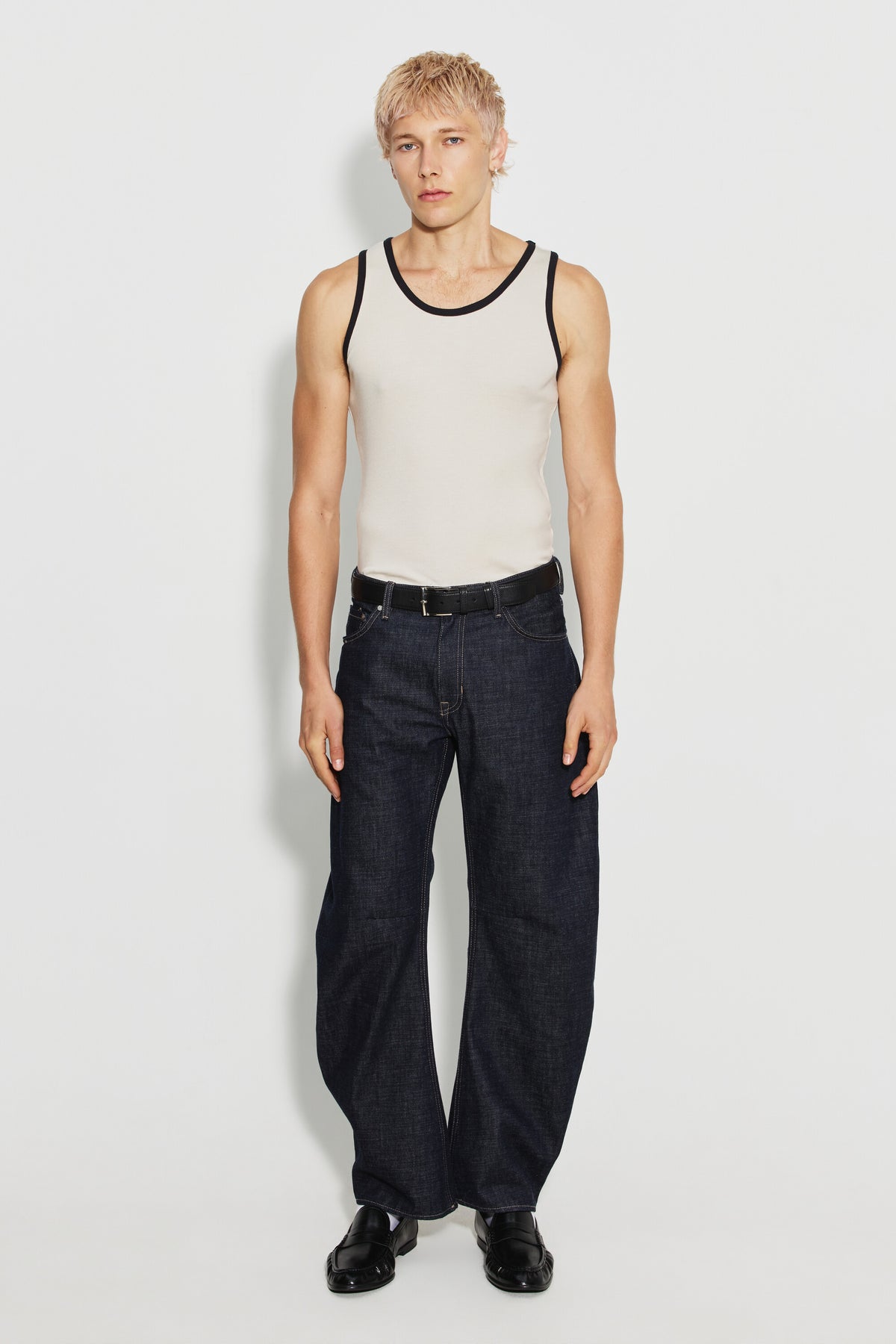 Débardeur homme écru et noir en coton Pima, porté avec un jean foncé et des chaussures noires, vue de face en pied.