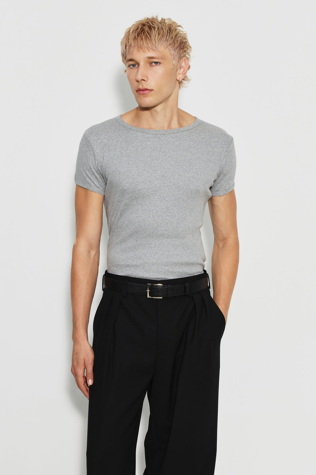 Maillot de corps homme gris chiné à manches courtes en coton Pima côtelé, porté de face avec un pantalon noir, les bras le long du corps. Made in France.