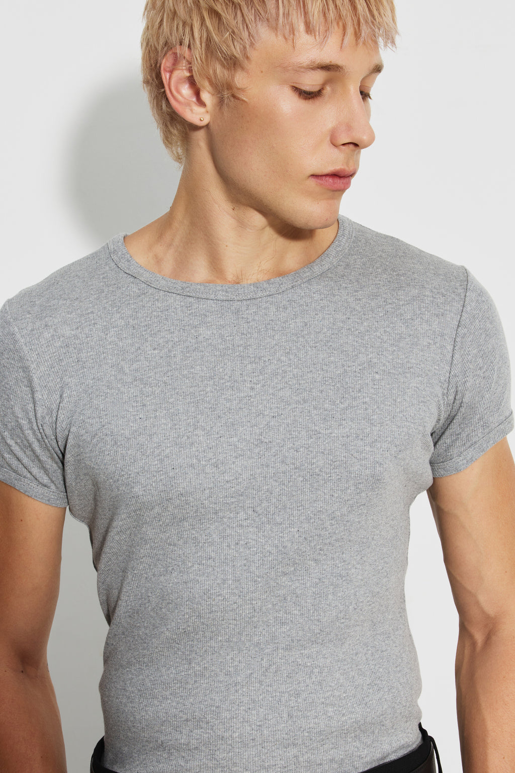 Maillot de corps homme gris chiné à manches courtes en coton Pima côtelé, vue rapprochée du col rond et de la maille, la tête tournée sur le côté.