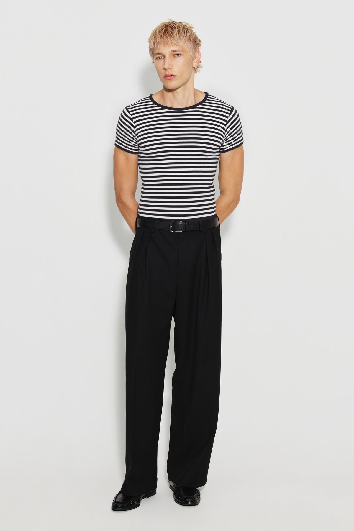 Maillot de corps homme noir et écru en coton bio côtelé à manches courtes, porté avec un pantalon noir, vue de face en pied.