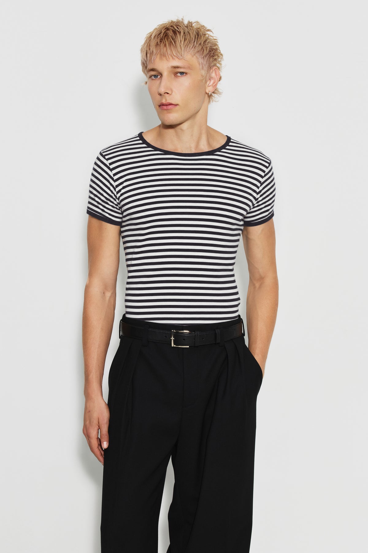 Maillot de corps homme noir et écru en coton bio côtelé à manches courtes, porté de face avec un pantalon noir ceinturé. Made in France.