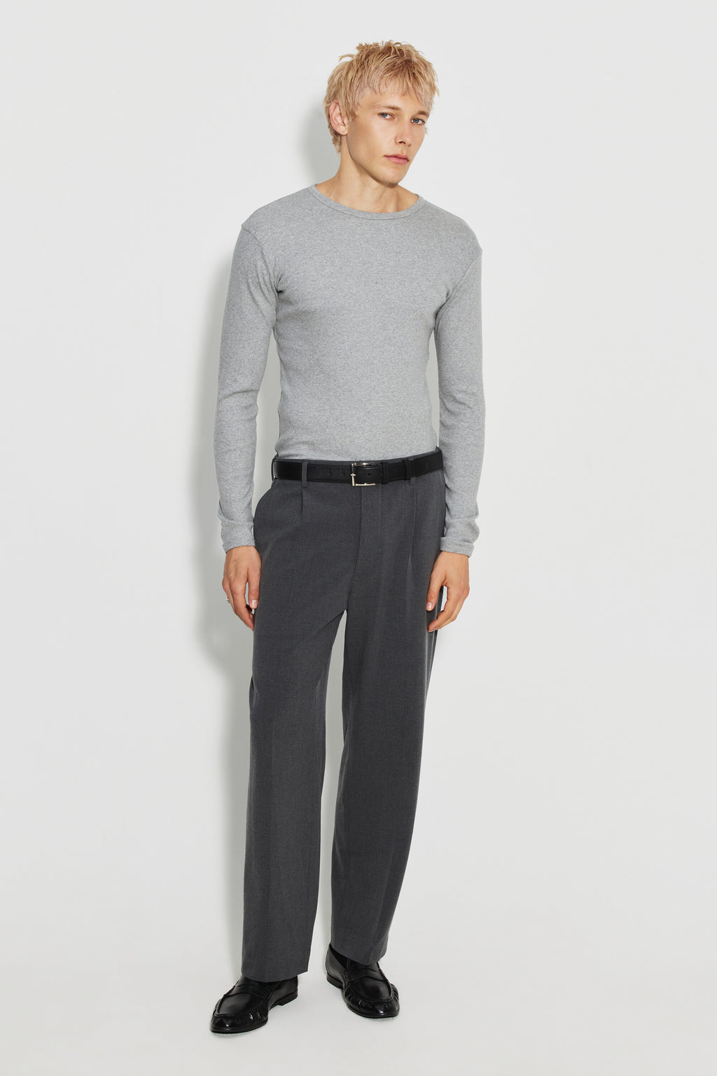 Maillot de corps homme gris chiné à manches longues en coton Pima, fabriqué à Roanne, porté avec un pantalon gris, vue en pied.