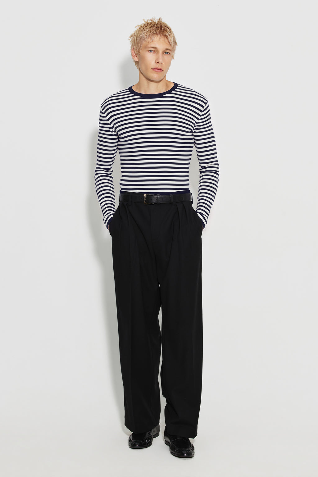 Maillot de corps homme bleu marine et écru en coton bio côtelé à manches longues, porté avec un pantalon noir, vue en pied.