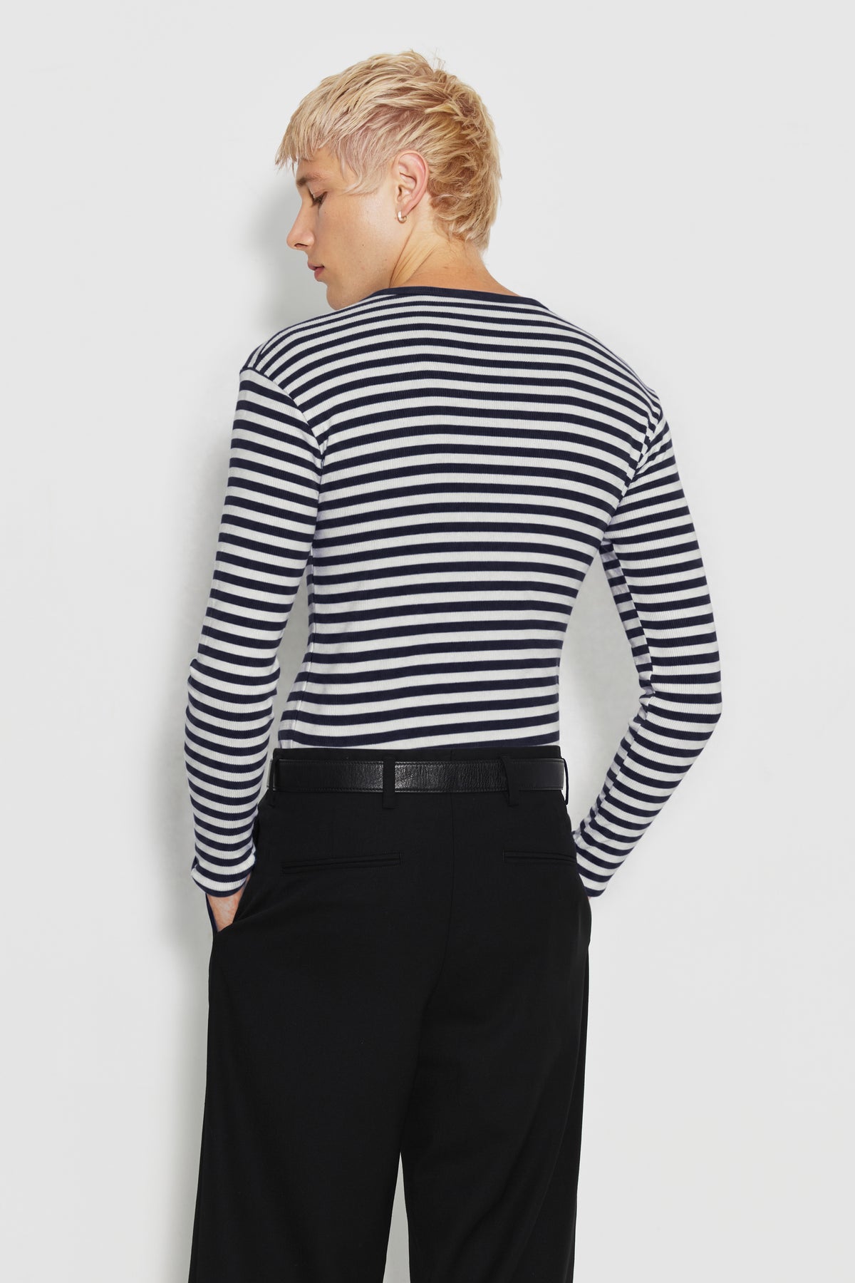 Maillot de corps homme bleu marine et écru en coton bio côtelé à manches longues, porté de dos avec un pantalon noir, vue des rayures et des manches longues.