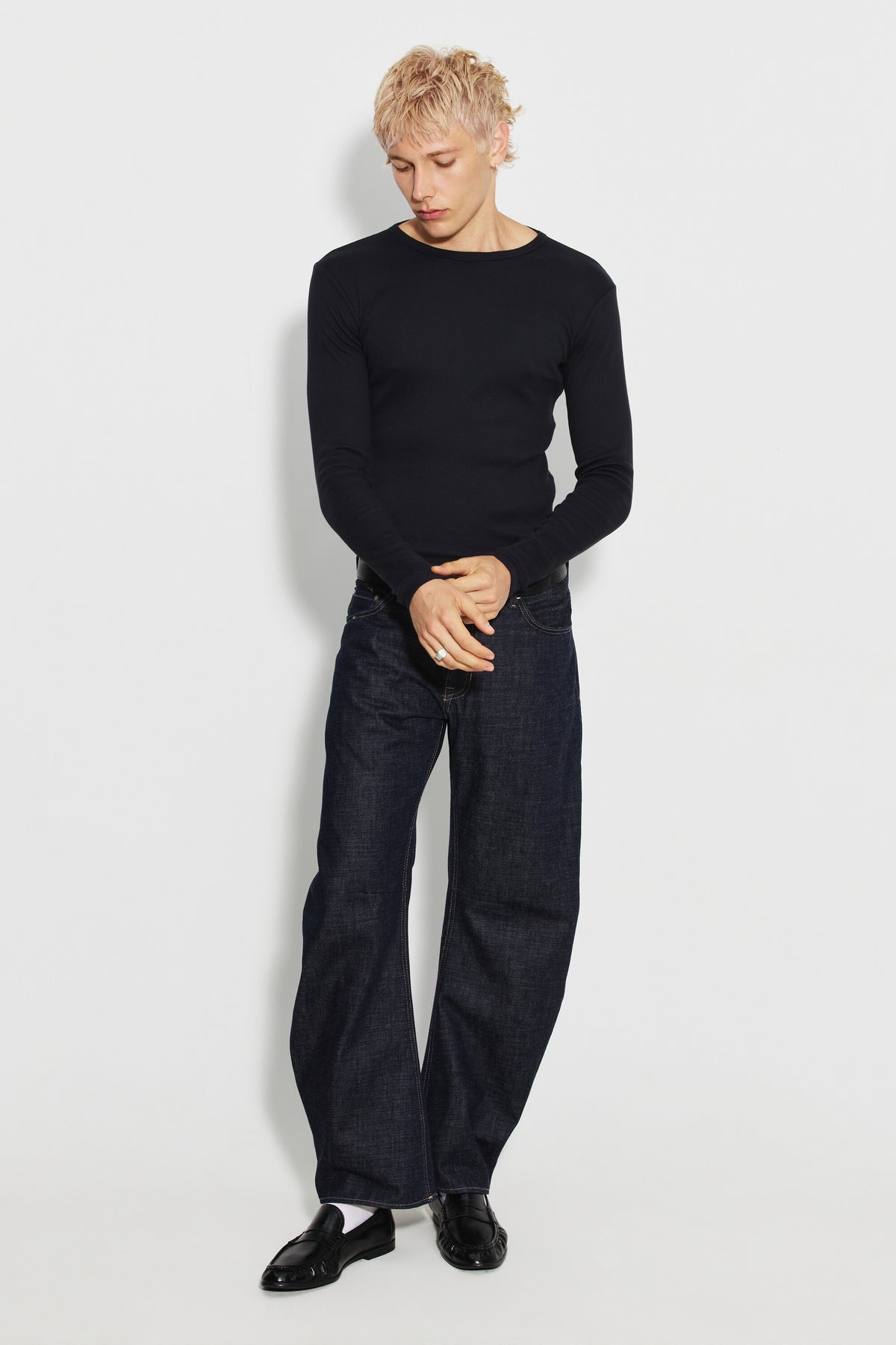 Maillot de corps homme noir à manches longues en coton Pima, fabriqué à Roanne, porté avec un jean bleu, vue en pied.