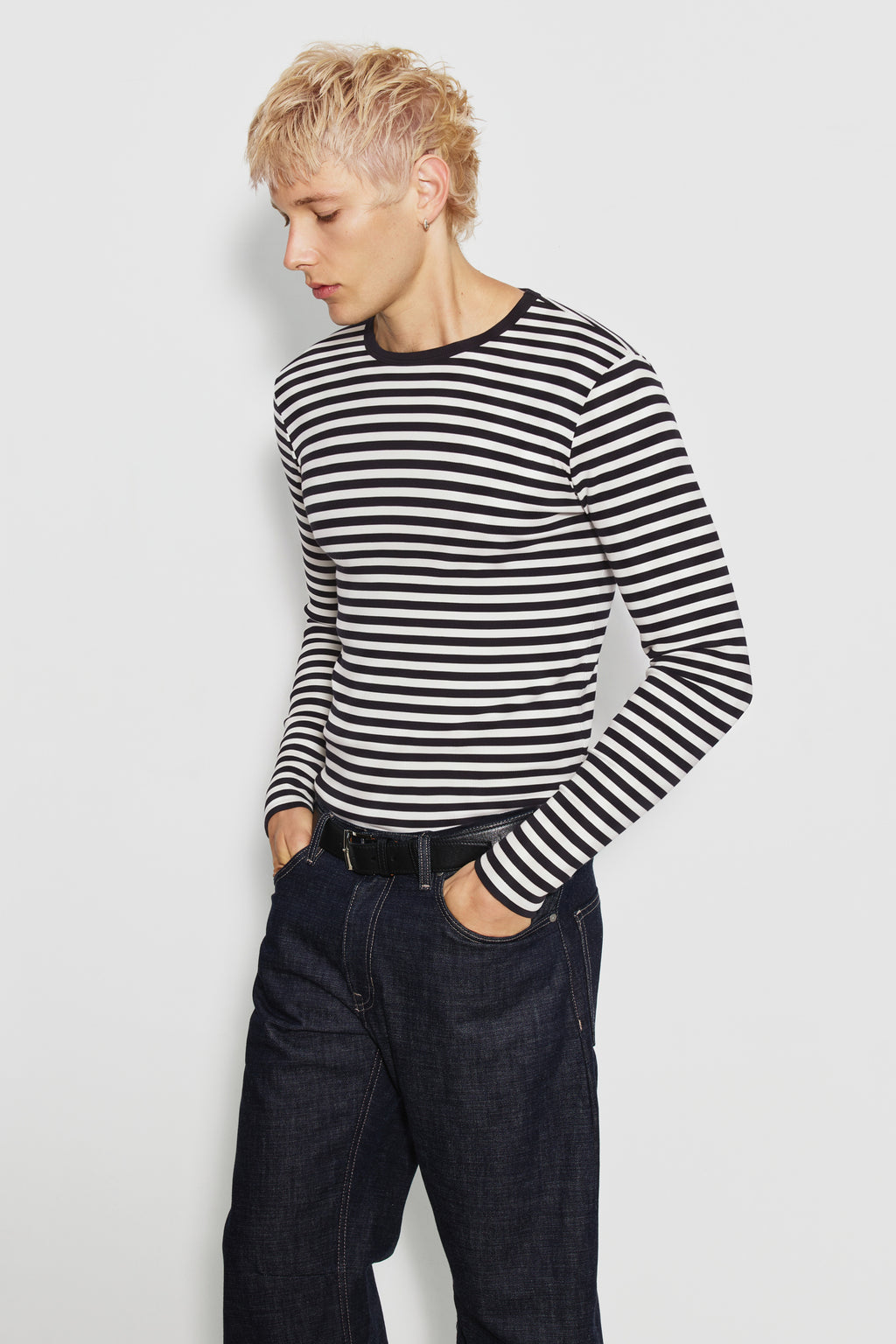 Maillot de corps homme noir et écru en coton bio côtelé à manches longues, porté avec un jean bleu, vue de face. Made in France.
