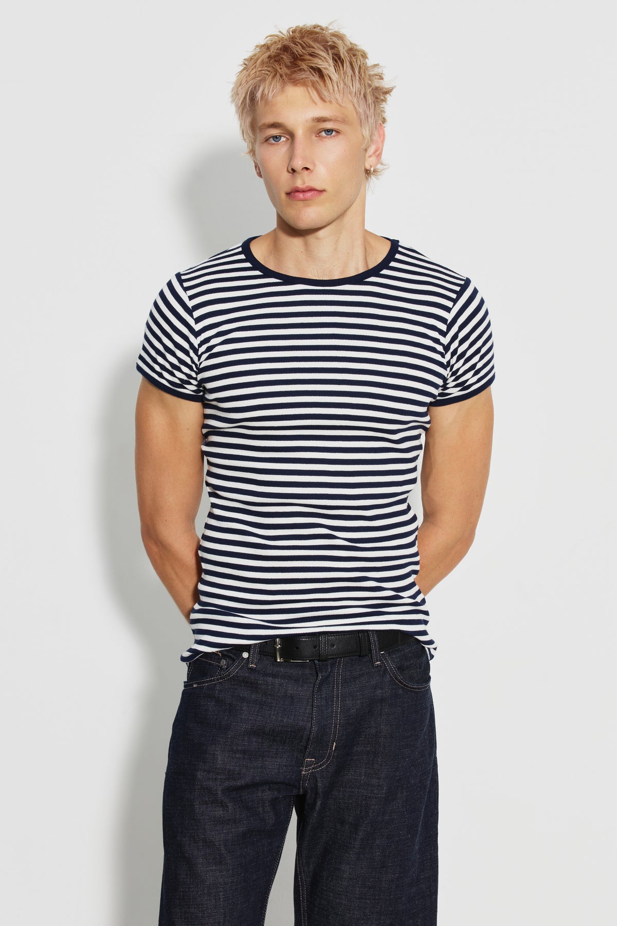 Maillot de corps homme bleu marine et écru en coton bio côtelé à manches courtes, porté de face avec un jean foncé, les mains derrière le dos. Made in France.