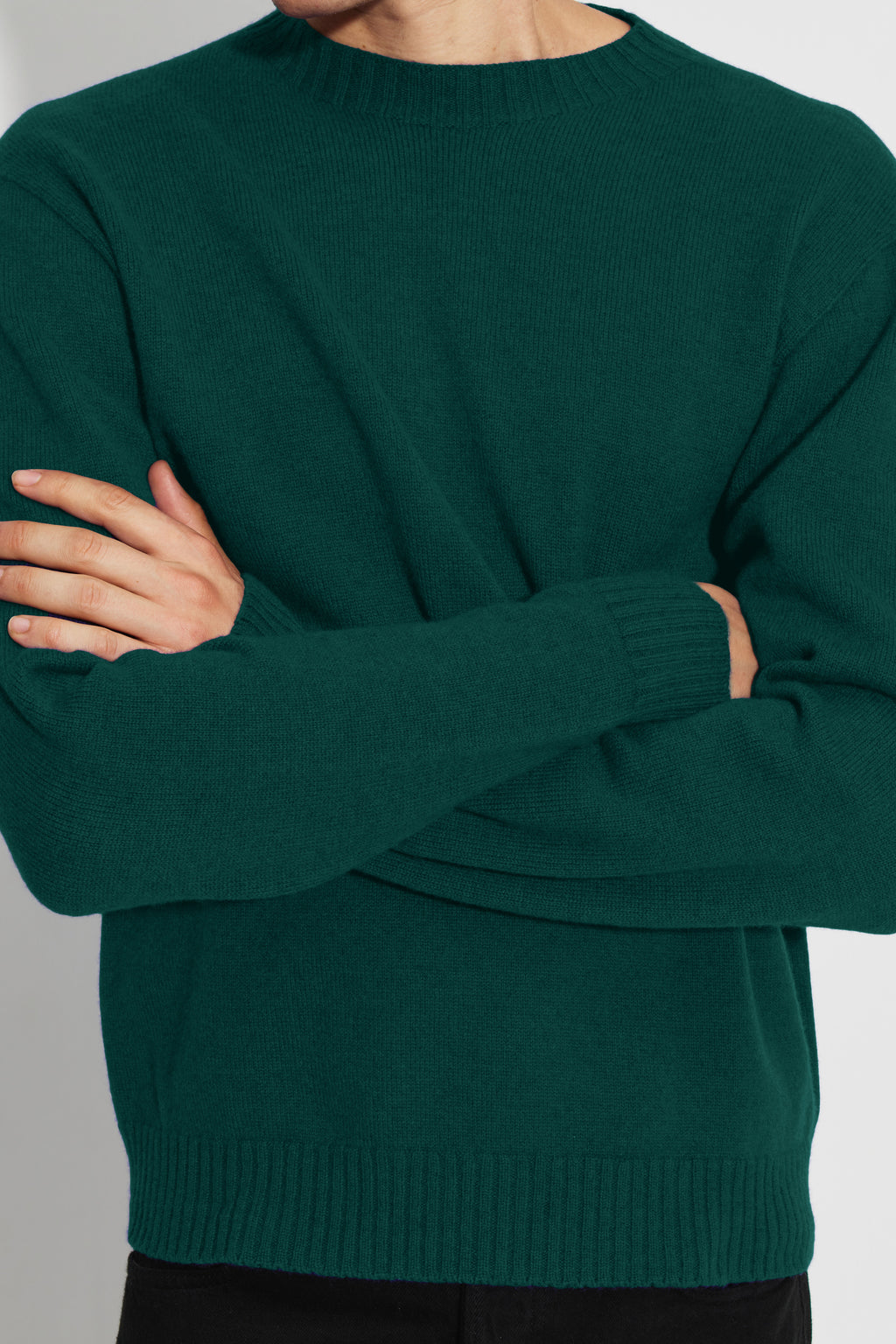 Pull homme vert en laine mérinos et cachemire, détail de la maille, des poignets et du bord-côte à la taille.