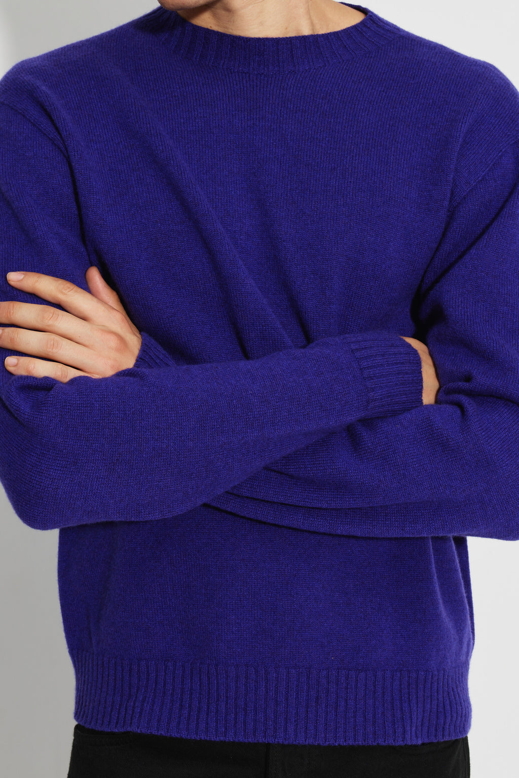 Pull mérinos et cachemire homme violet – gros plan de face sur la maille et les poignets, bras croisés.
