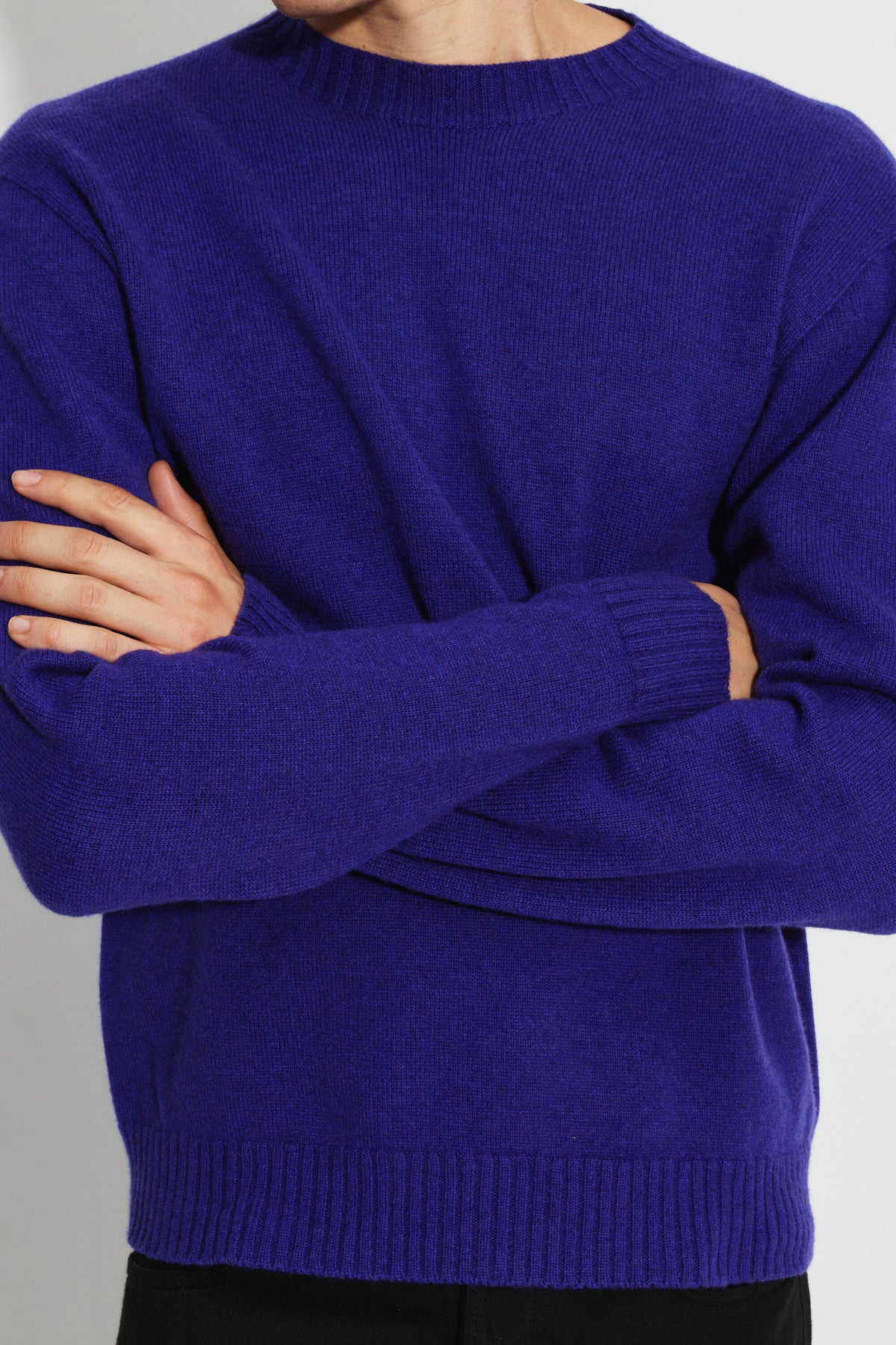 Pull mérinos et cachemire homme violet – gros plan de face sur la maille et les poignets, bras croisés.