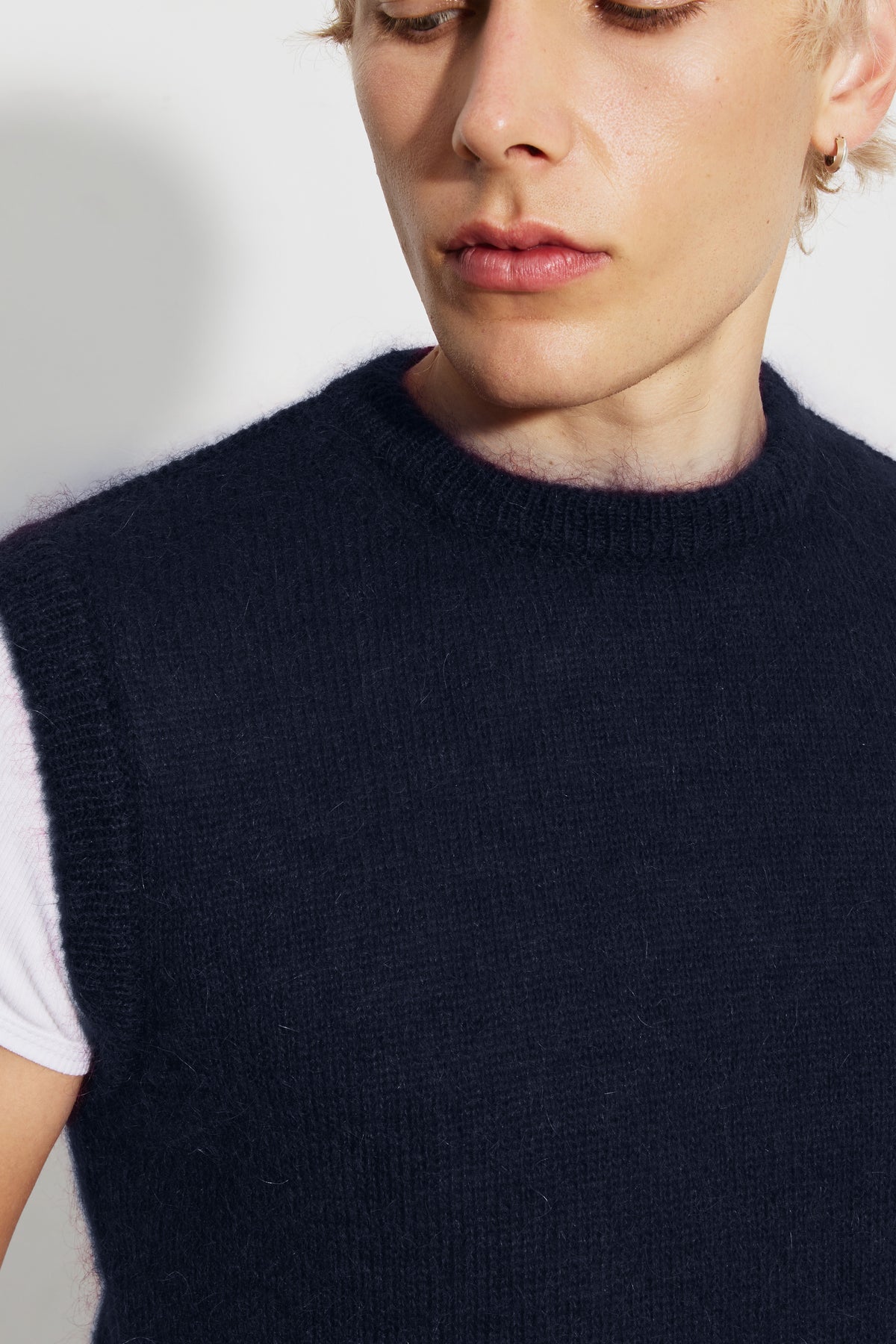 Pull homme bleu marine en mohair sans manches, détail du col rond et de la maille.