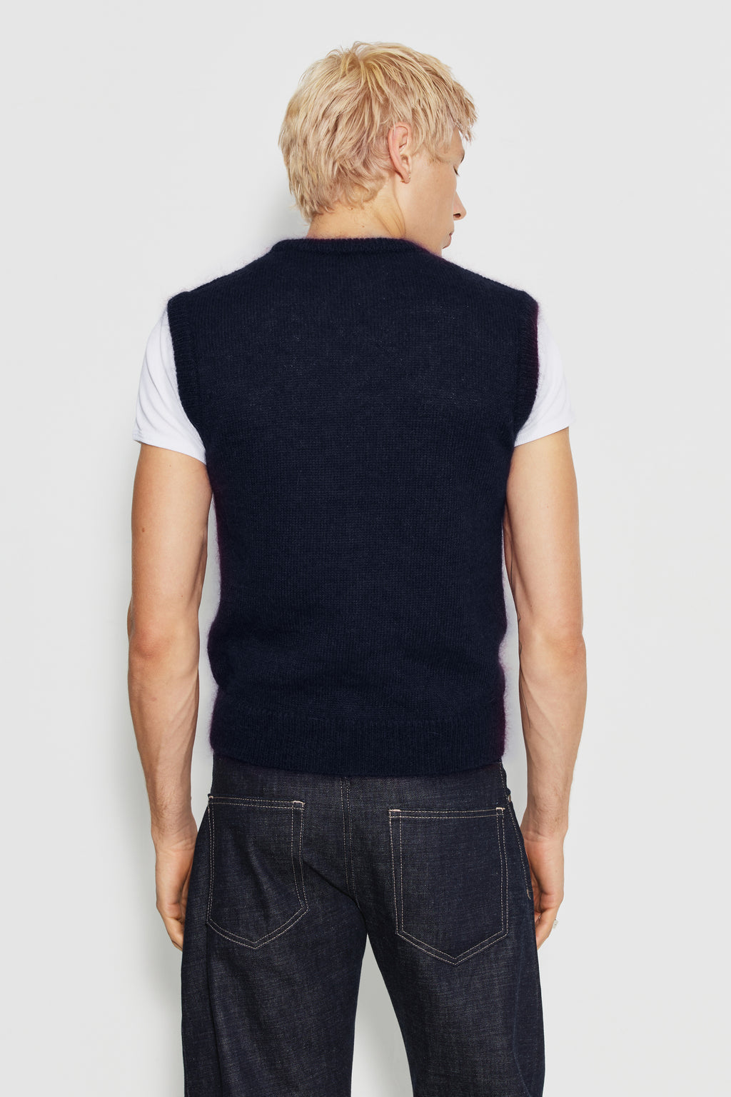 Pull homme bleu marine en mohair sans manches, vue de dos sur un maillot de corps blanc.