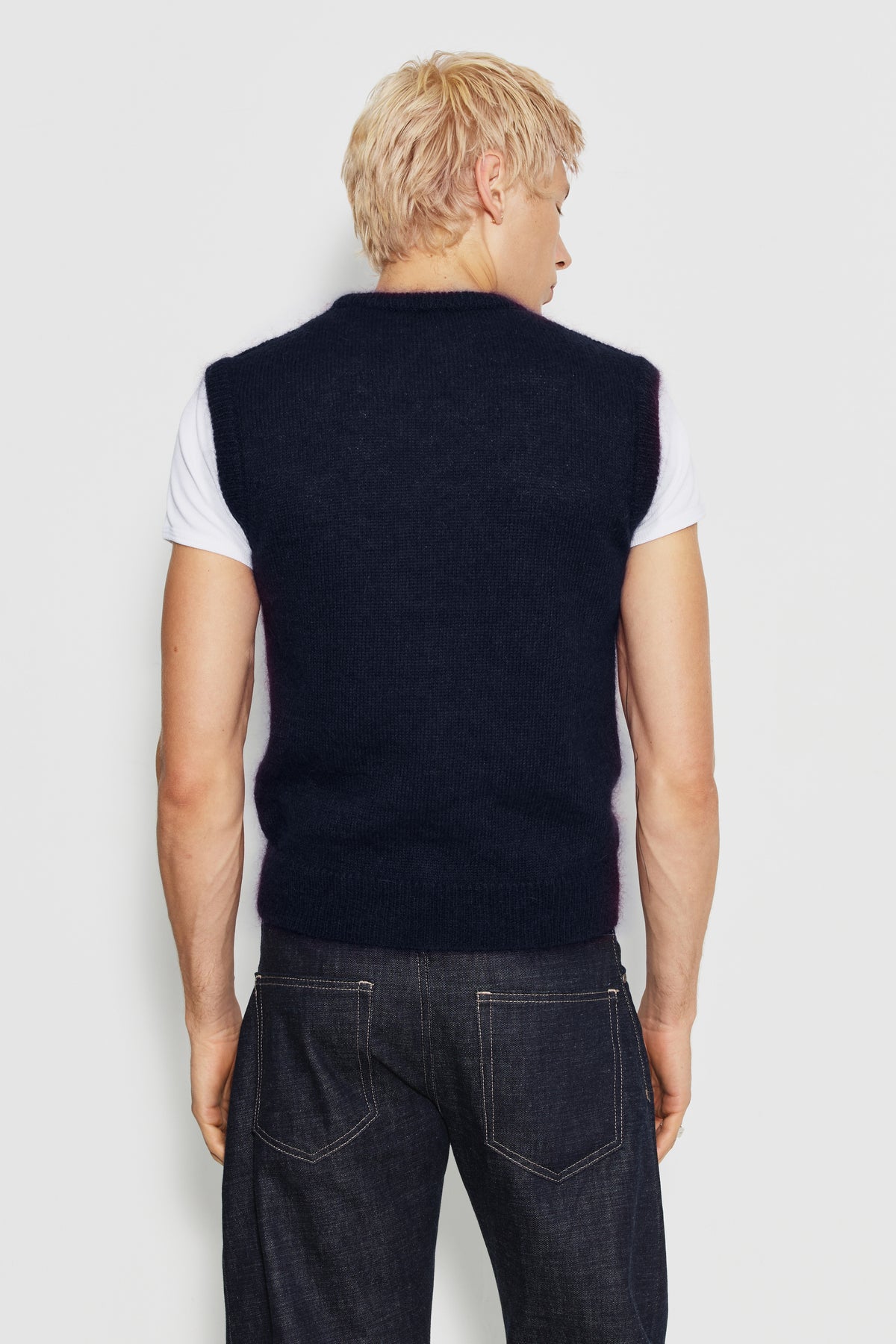 Pull homme bleu marine en mohair sans manches, vue de dos sur un maillot de corps blanc.