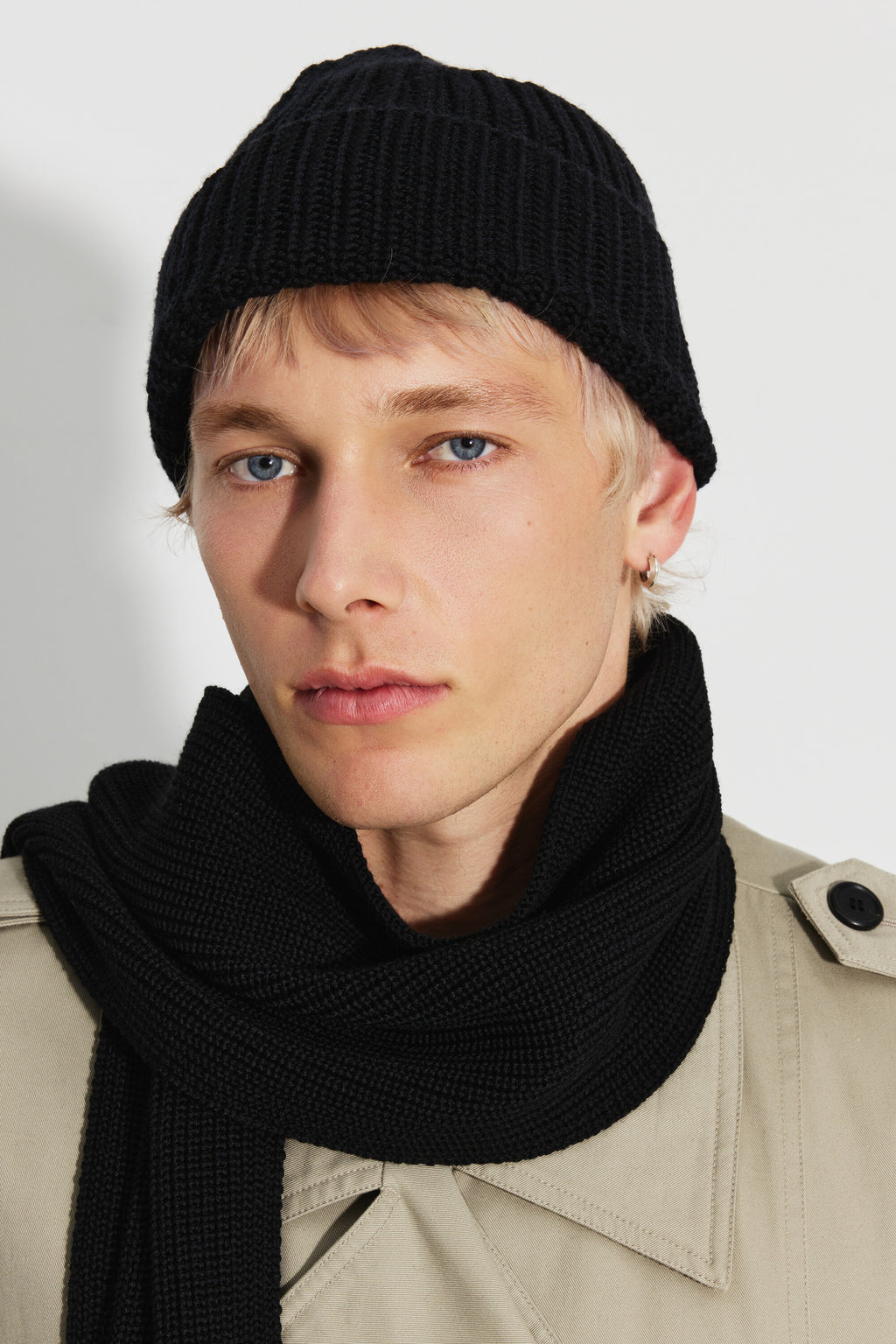 Bonnet homme noir en laine mérinos, portrait rapproché montrant le revers et la maille côtelée, avec une écharpe noire. Made in France.