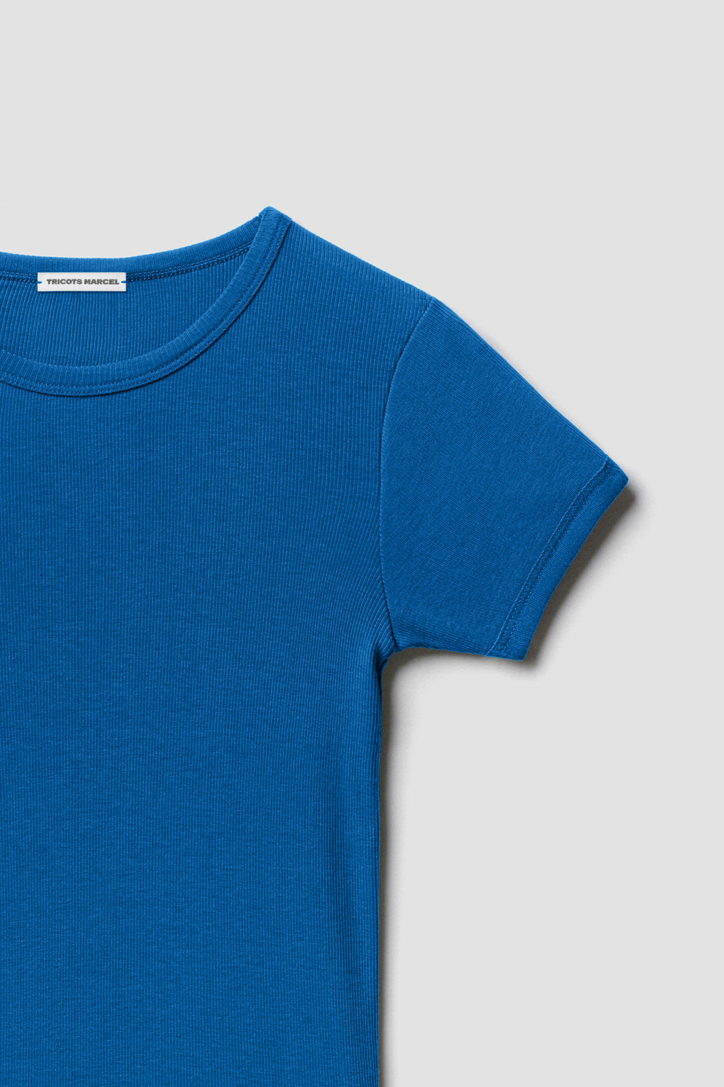 Maillot de corps bleu à manches courtes en coton Pima côtelé, détail du col rond, de l’épaule et de la manche.