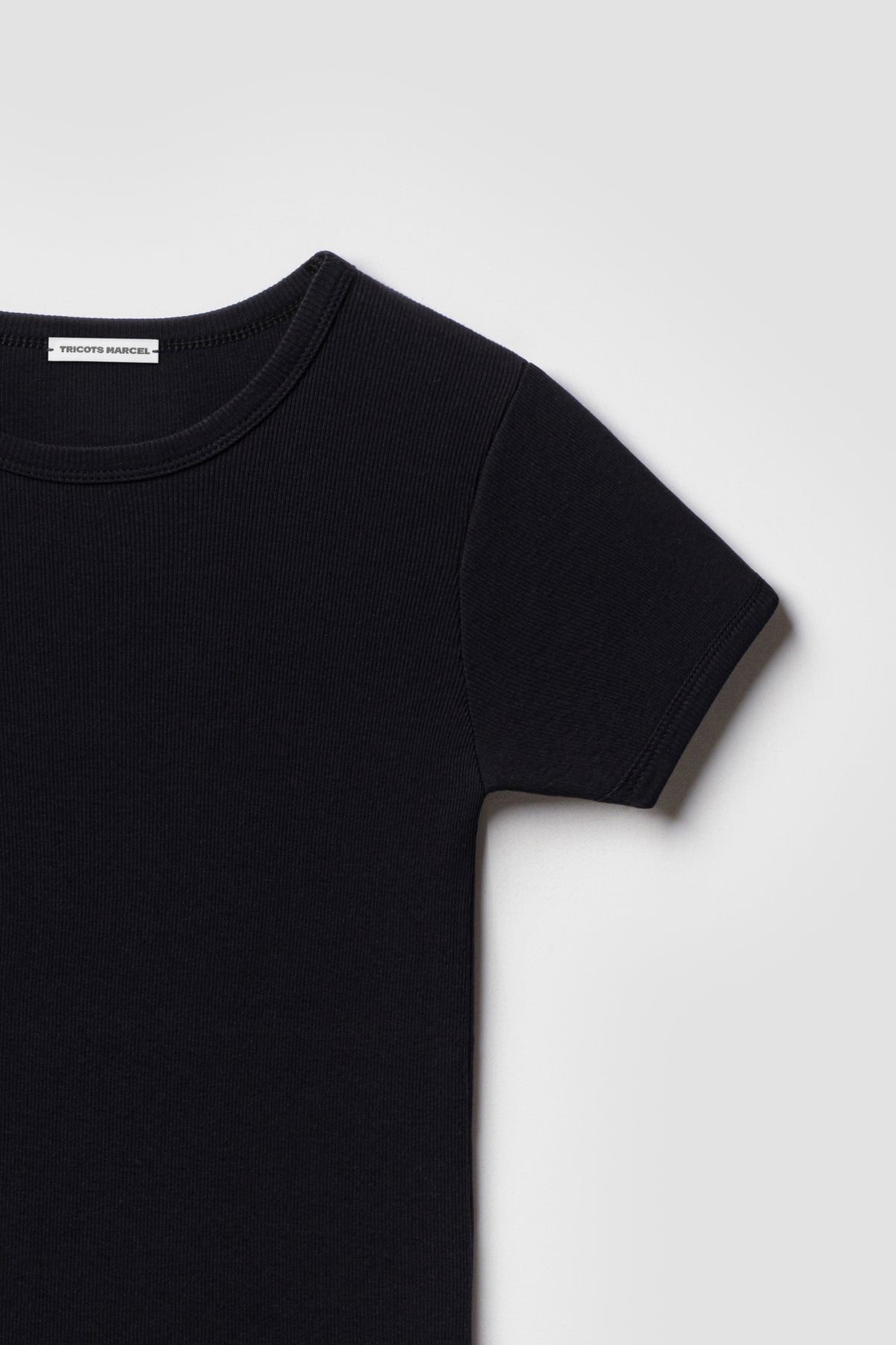 Maillot de corps homme et femme noir à manches courtes en coton Pima côtelé, détail du col rond et de la manche. Made in France.