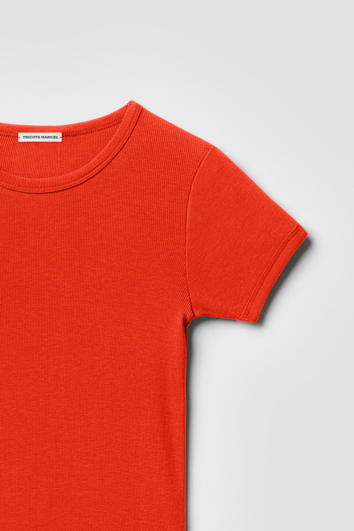 Maillot de corps orange à manches courtes en coton Pima côtelé, détail du col rond, de l’épaule et de la manche.