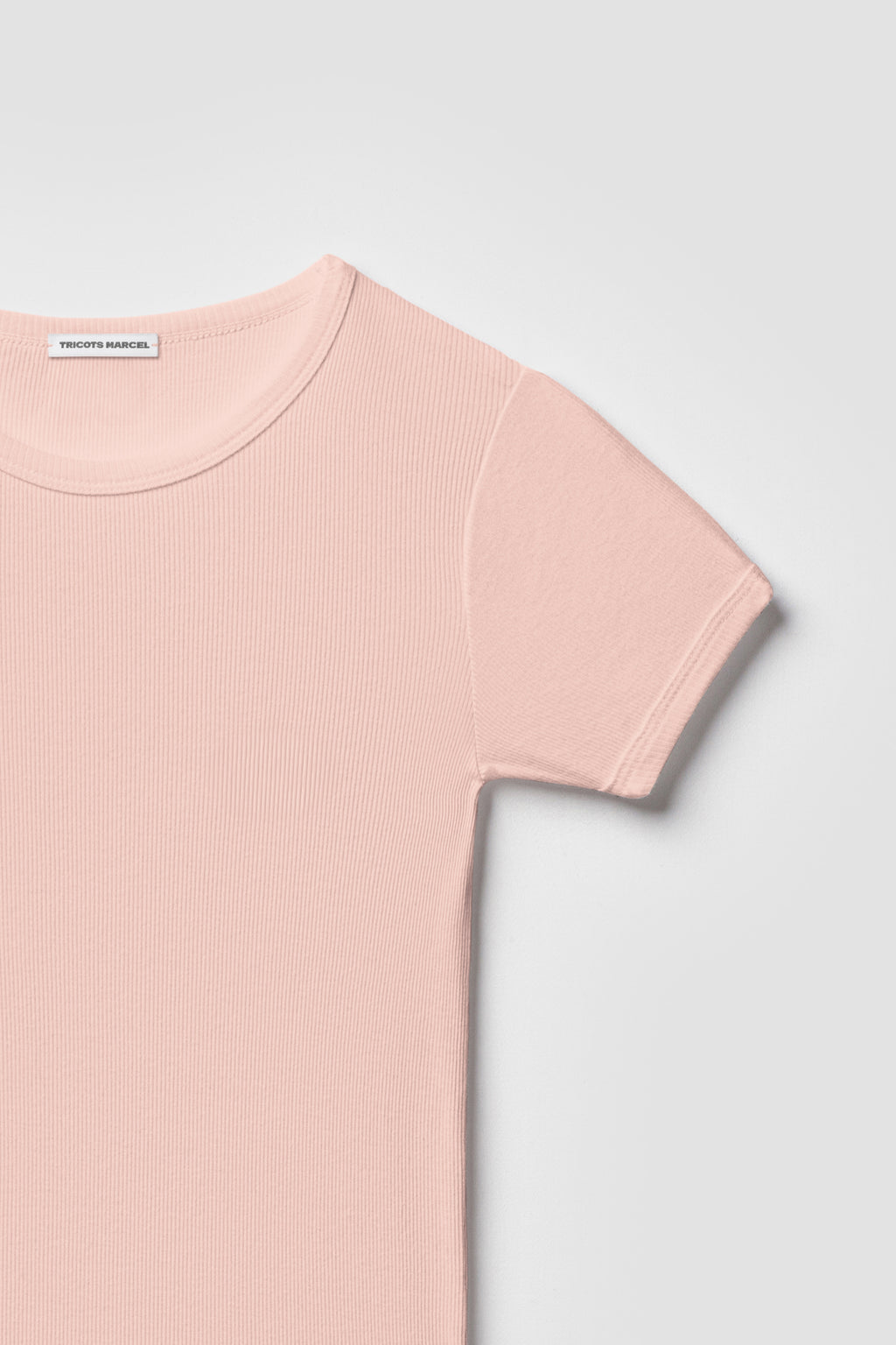 Maillot de corps rose à manches courtes en coton Pima côtelé, détail du col rond, de l’épaule et de la manche.