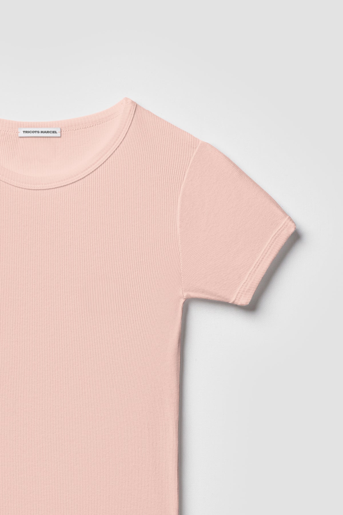 Maillot de corps rose à manches courtes en coton Pima côtelé, détail du col rond, de l’épaule et de la manche.