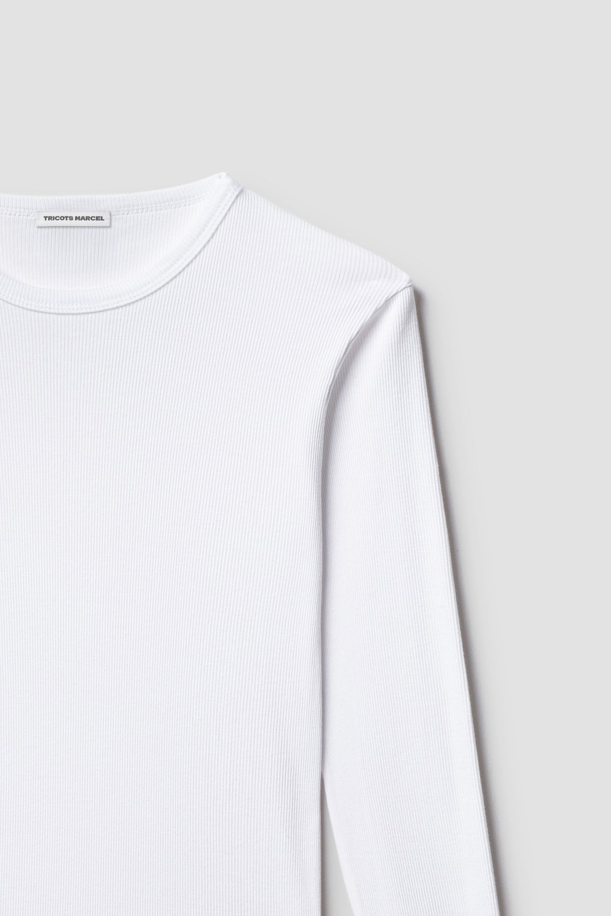 Maillot de corps blanc à manches longues en coton Pima côtelé, détail du col rond, de l’épaule et de la maille.