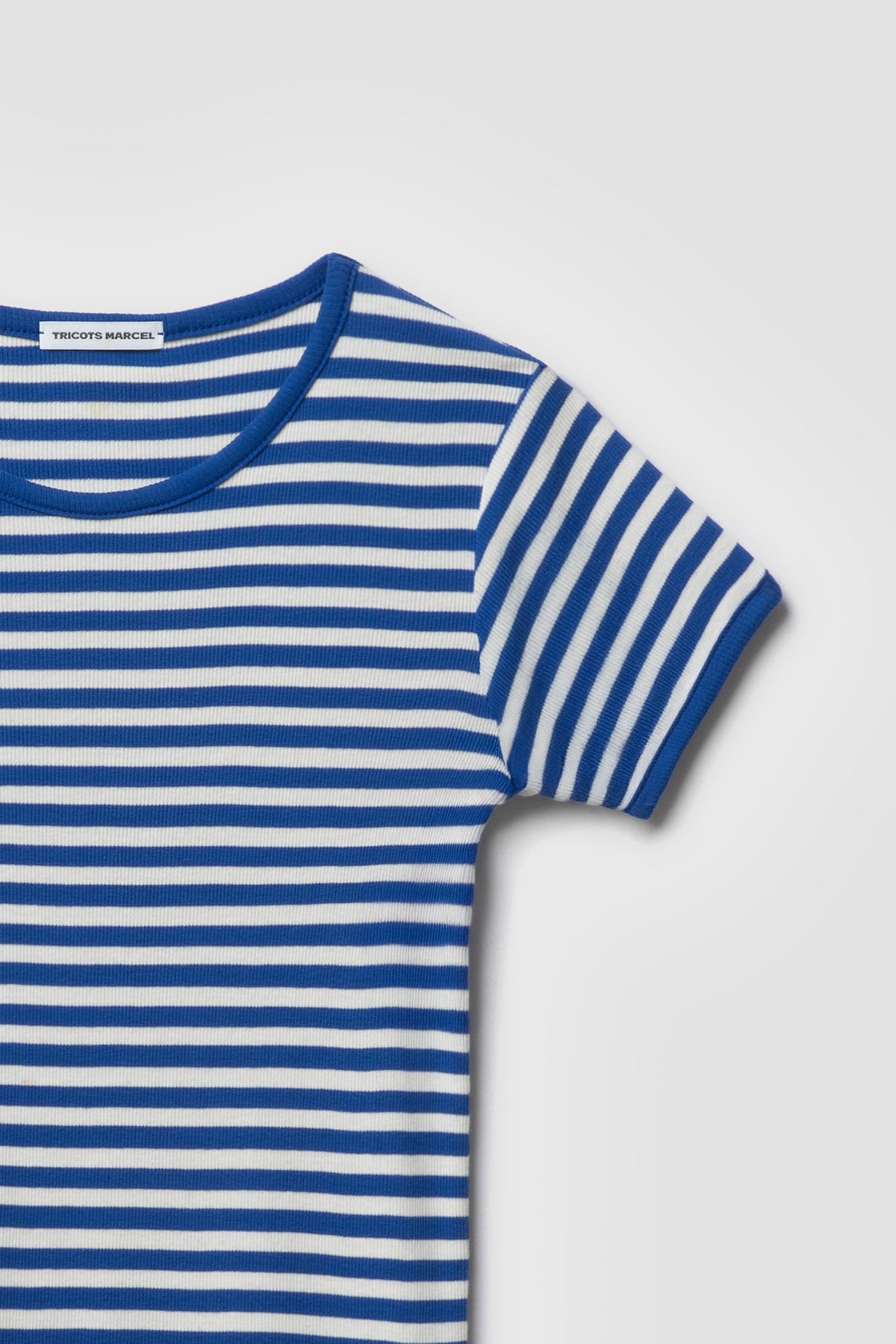 Maillot de corps marinière rayé bleu et écru à manches courtes en coton bio côtelé, détail du col rond, de l’épaule et de la manche. Made in France.