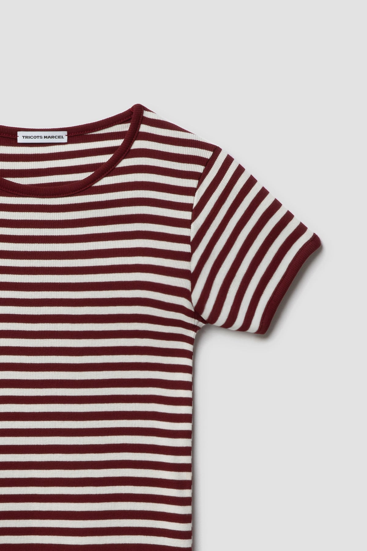 Maillot de corps marinière rayé bordeaux et écru à manches courtes en coton bio côtelé, détail du col rond, de l’épaule et de la manche. Made in France.