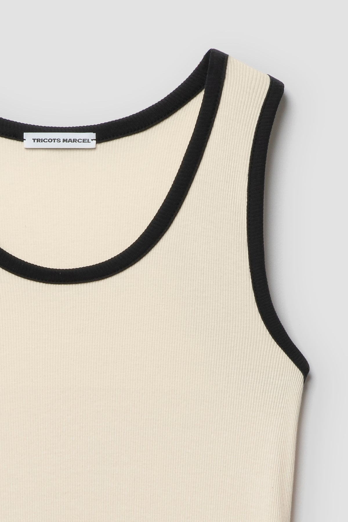 Débardeur homme et femme écru et noir en coton Pima, détail de l’encolure et de l’épaule à bordure noire. Made in France.