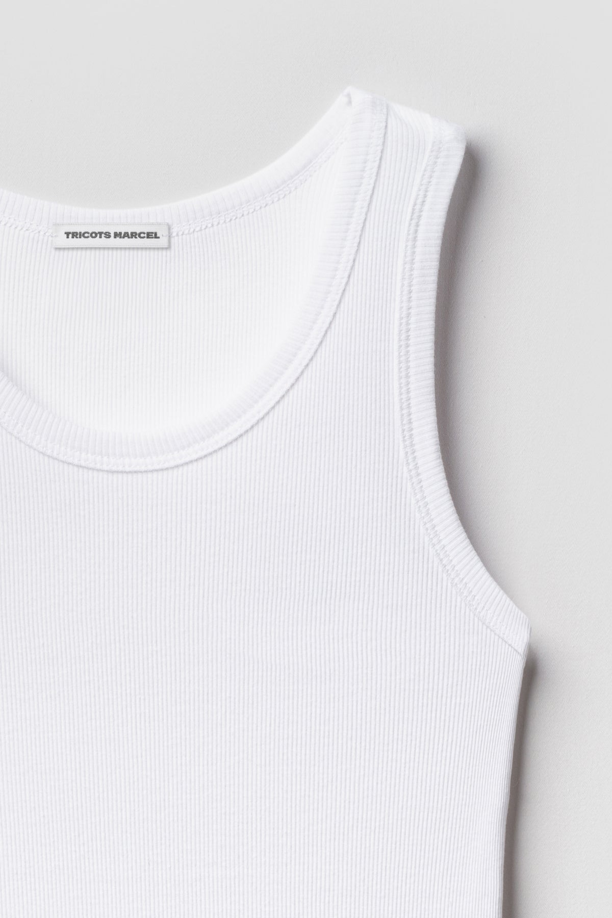 Débardeur Marcel Signature blanc en coton Pima côtelé, détail de l’encolure, de la bretelle et de la maille.