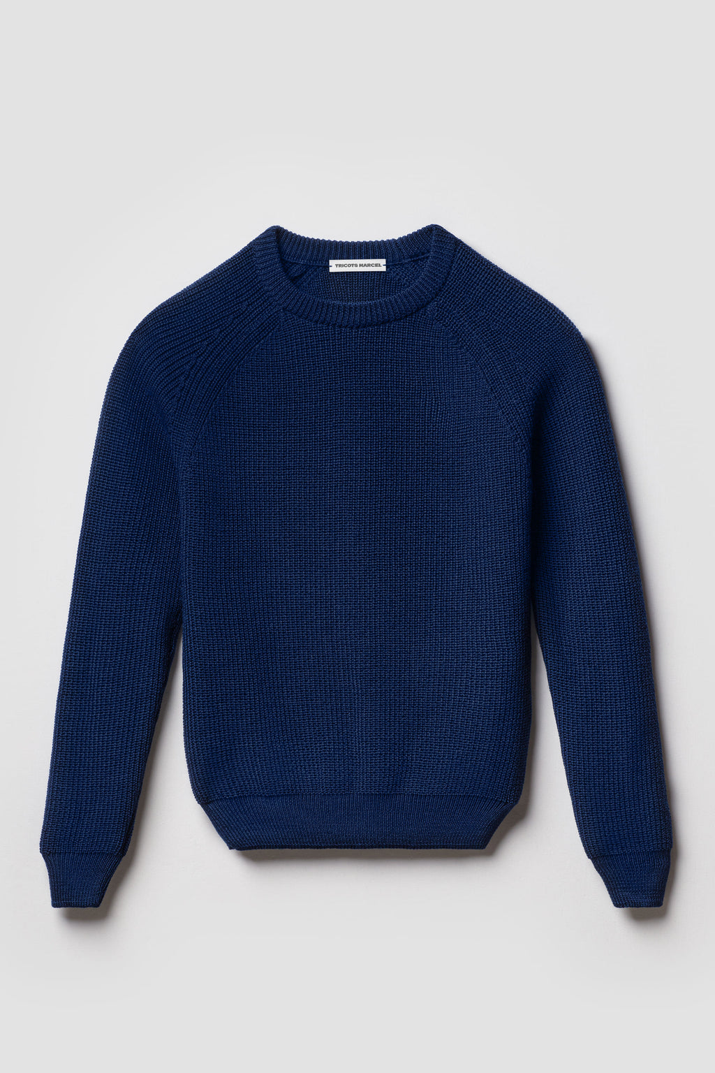 Pull bleu en laine mérinos à manches raglan, vue de face montrant le col rond et la maille perlée.