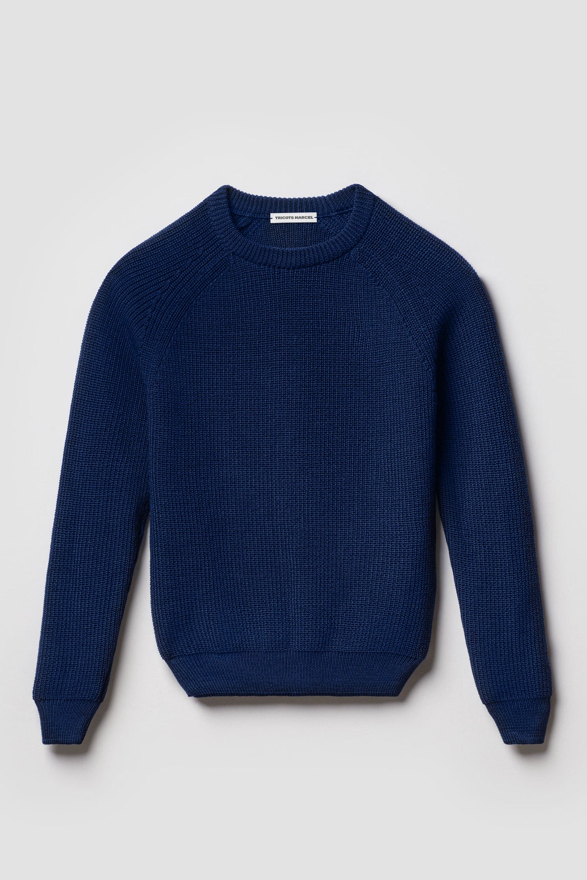Pull bleu en laine mérinos à manches raglan, vue de face montrant le col rond et la maille perlée.