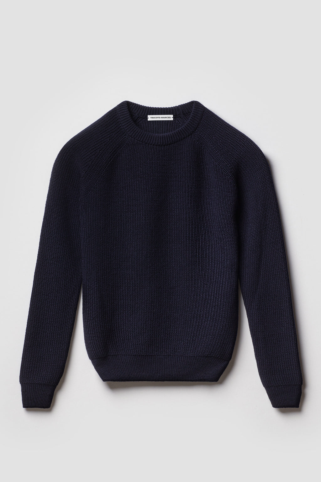 Pull homme et femme bleu marine en laine mérinos à manches raglan, packshot de face montrant le col rond et la maille perlée.