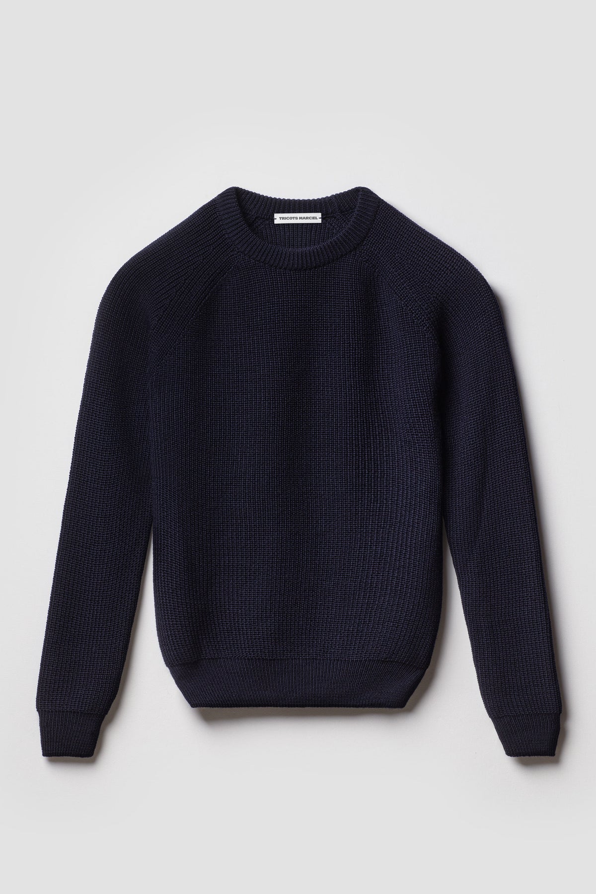 Pull homme et femme bleu marine en laine mérinos à manches raglan, packshot de face montrant le col rond et la maille perlée.