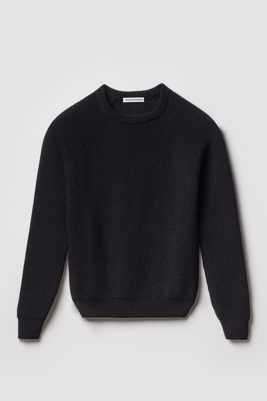 Pull homme et femme noir en laine mérinos à manches raglan, packshot de face montrant le col rond et la maille perlée.