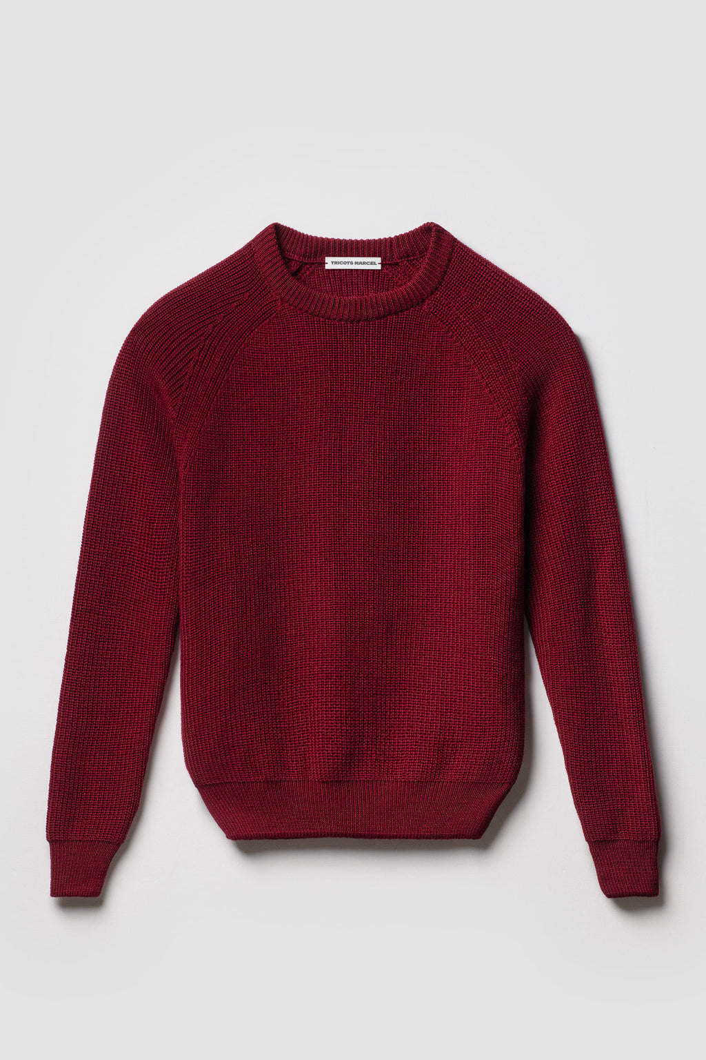 Pull rouge rubis en laine mérinos à manches raglan, vue de face montrant le col rond et la maille perlée.