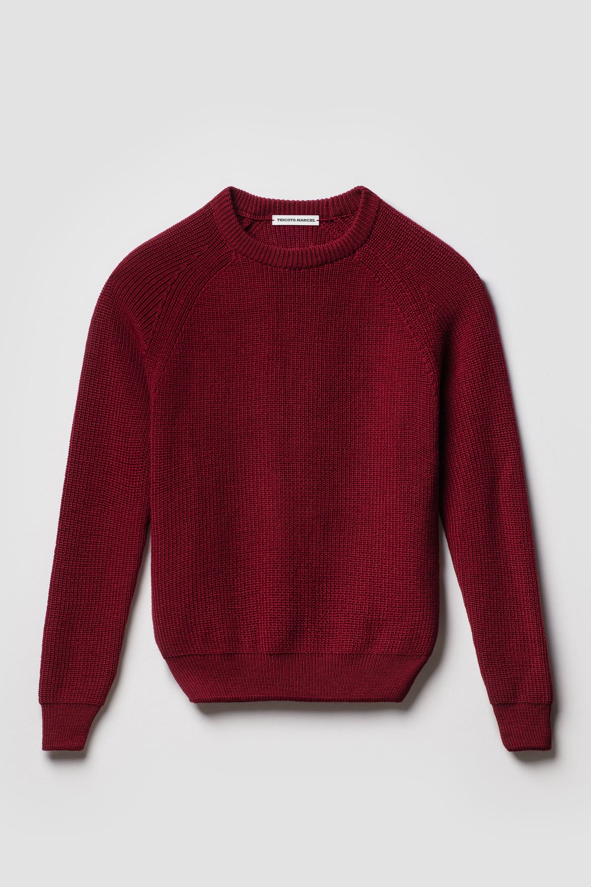 Pull rouge rubis en laine mérinos à manches raglan, vue de face montrant le col rond et la maille perlée.