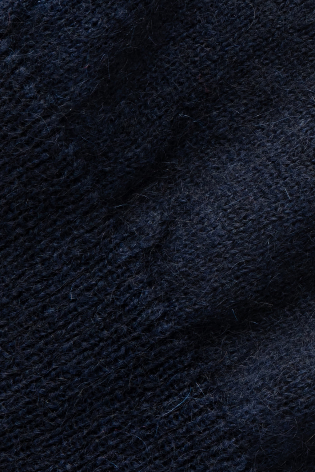 Pull bleu marine en mohair, gros plan sur la maille duveteuse.