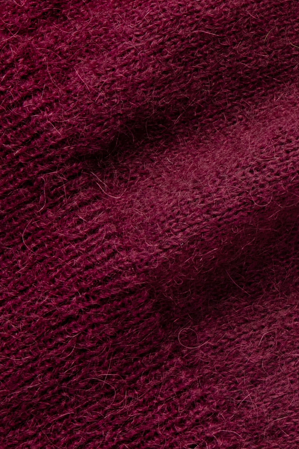 Pull bordeaux en mohair, gros plan sur la maille duveteuse.