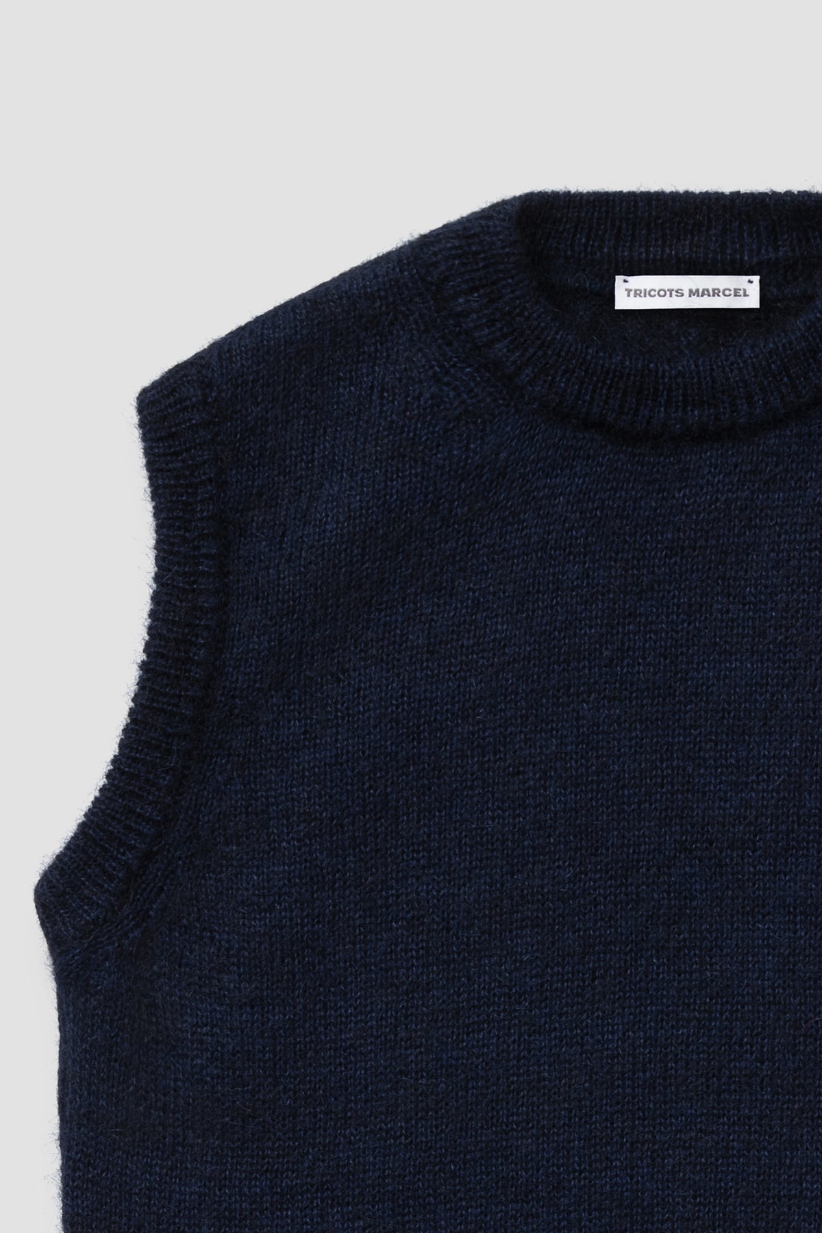 Pull bleu marine en mohair sans manches, détail du col rond et de l'emmanchure.