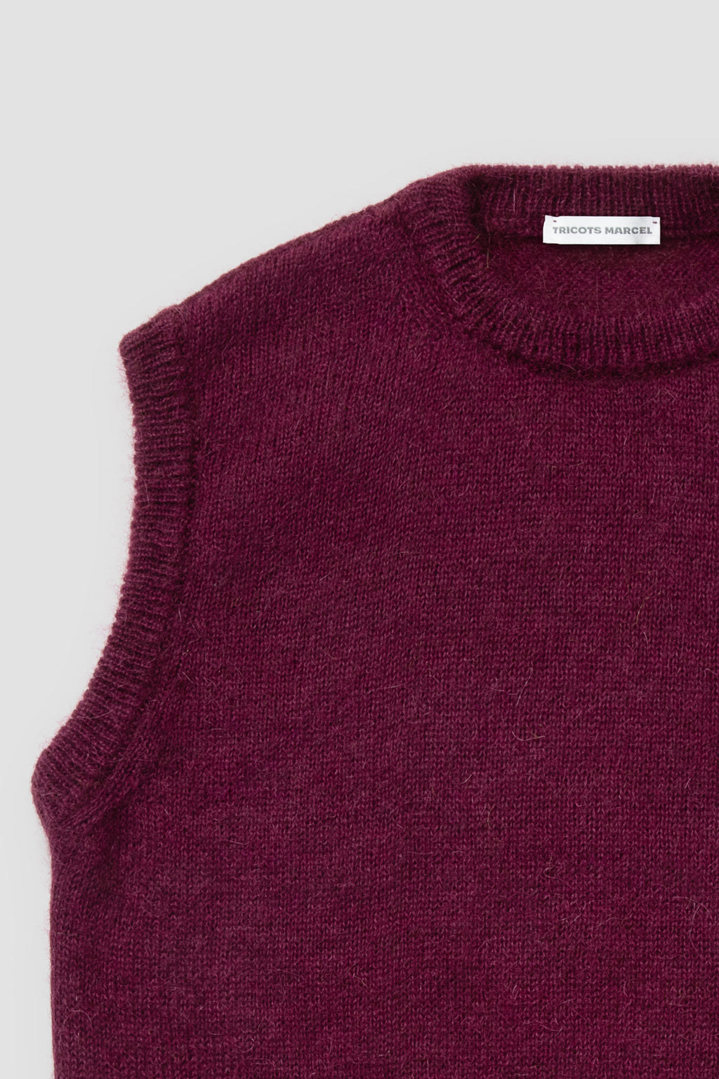 Pull bordeaux en mohair sans manches, détail du col rond et de l'emmanchure.