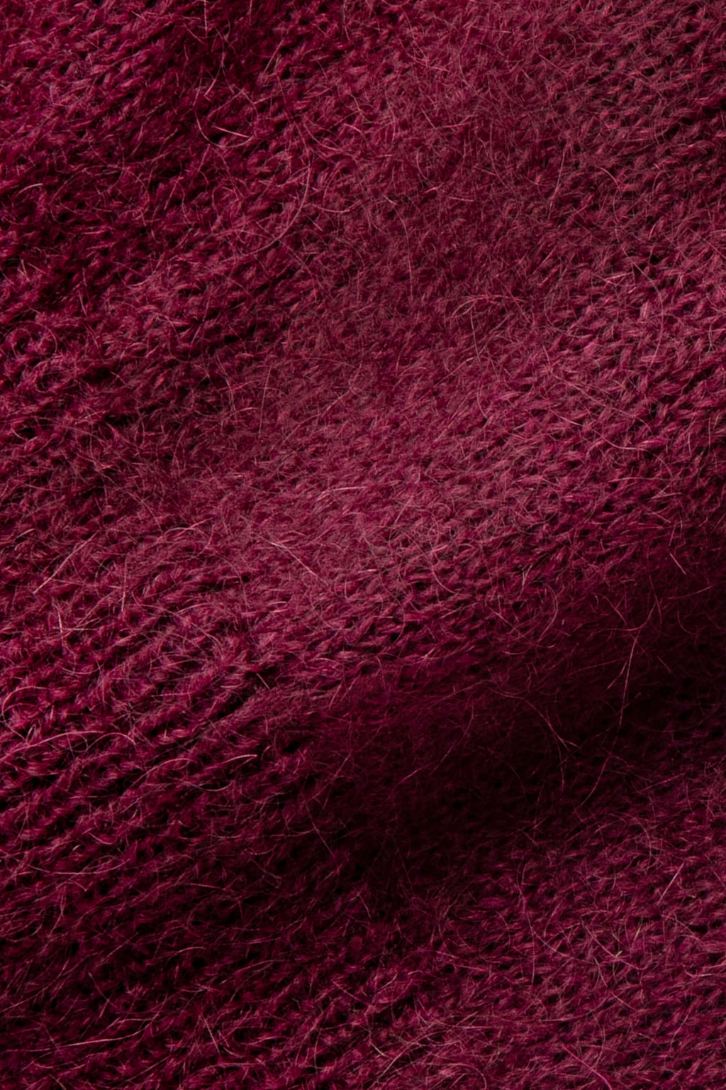 Pull bordeaux en mohair sans manches, gros plan sur la maille duveteuse.