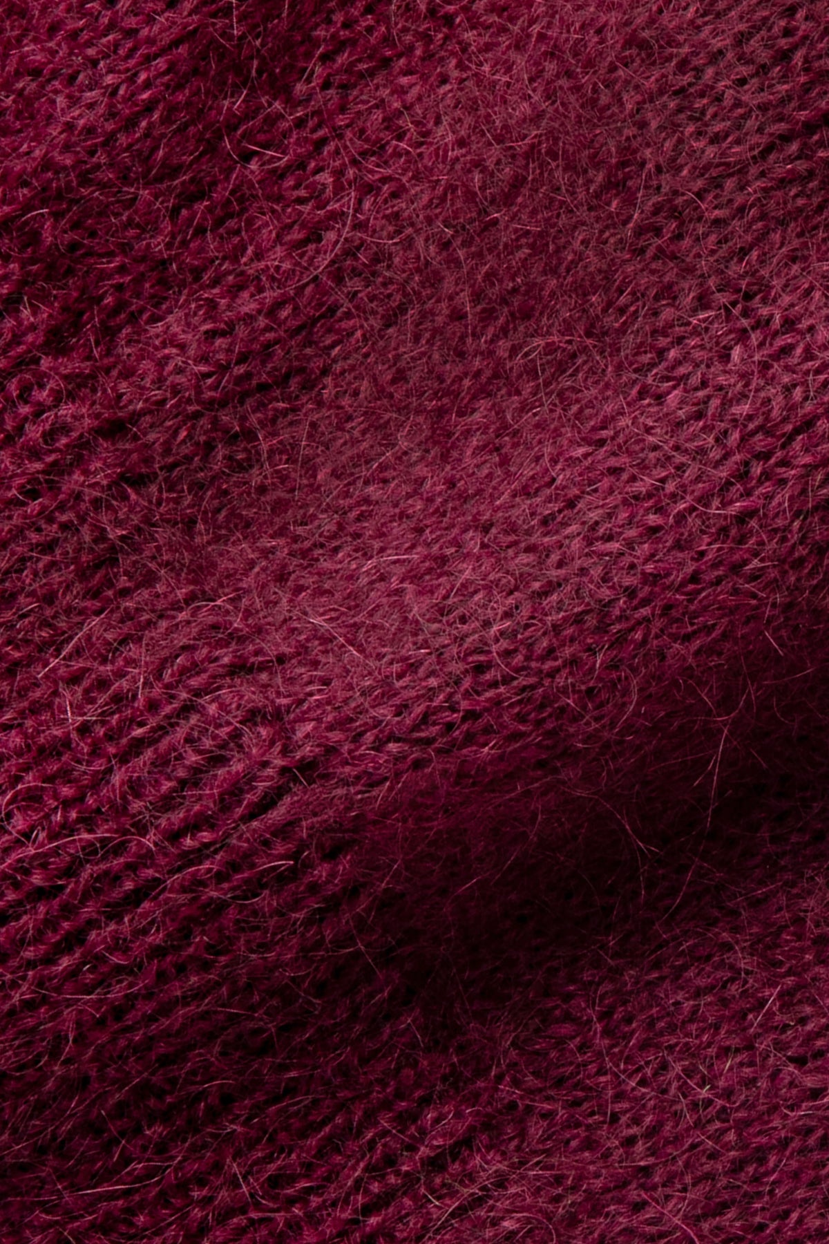 Pull bordeaux en mohair sans manches, gros plan sur la maille duveteuse.