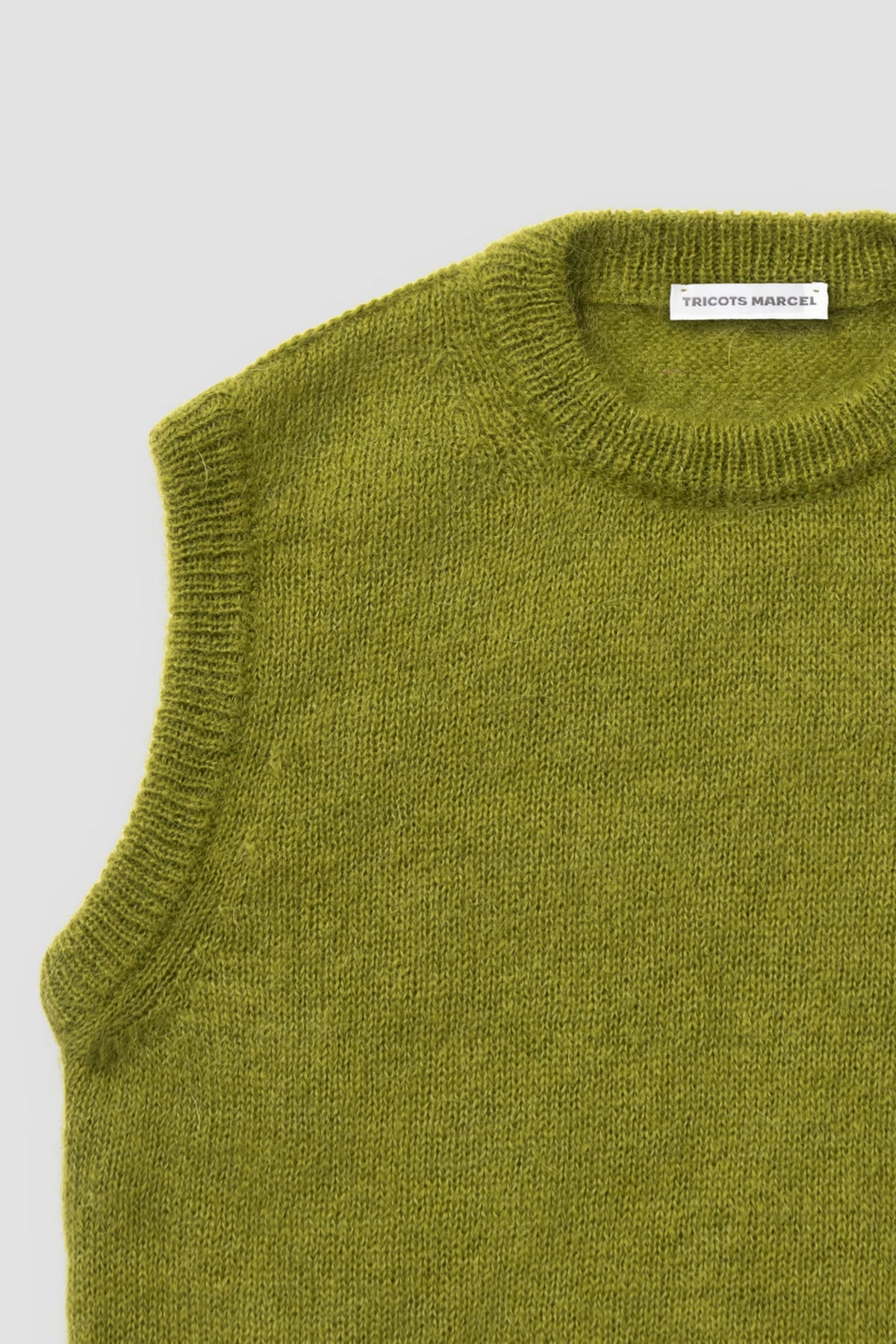 Pull vert mousse en mohair sans manches, détail du col rond et de l'emmanchure.