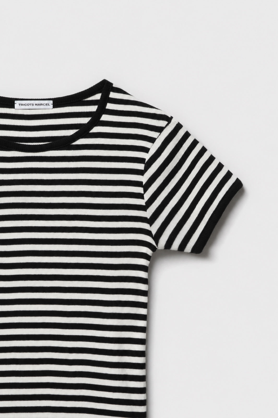 Détail du maillot de corps marinière rayé noir et écru en coton bio côtelé : col rond, manche courte et finitions noires.